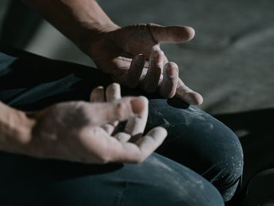 Close-up of chalked hands gripping a pull-up bar