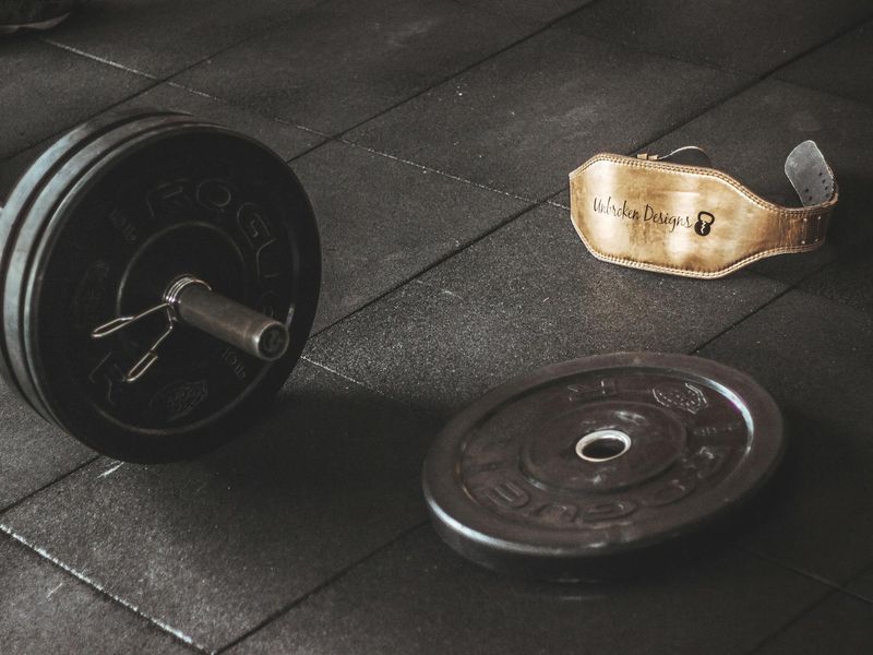 Man lifting heavy iron weights in a moody atmospheric gym